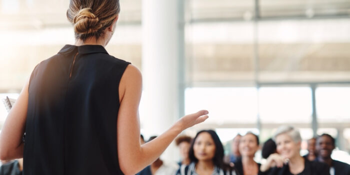 A professional woman giving a presentation in a room