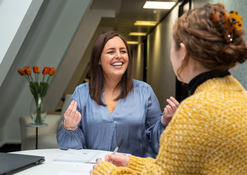 Two professionals building rapport through an open, engaged conversation during a coaching session