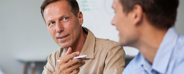 A man in conversation with a colleague