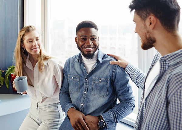 Colleagues building a kind, supportive team culture through friendly workplace interaction