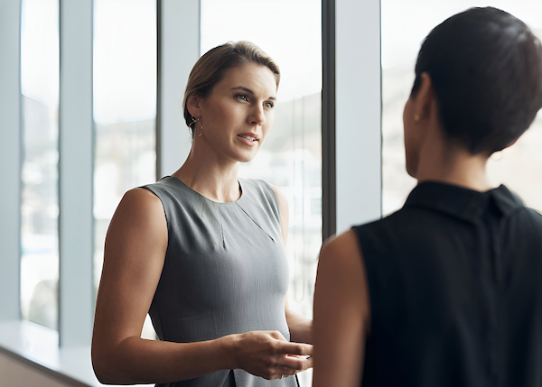Two professionals engaged in a calm, focused conversation about a challenging topic